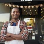 Black male business owner standing outside coffee shop
